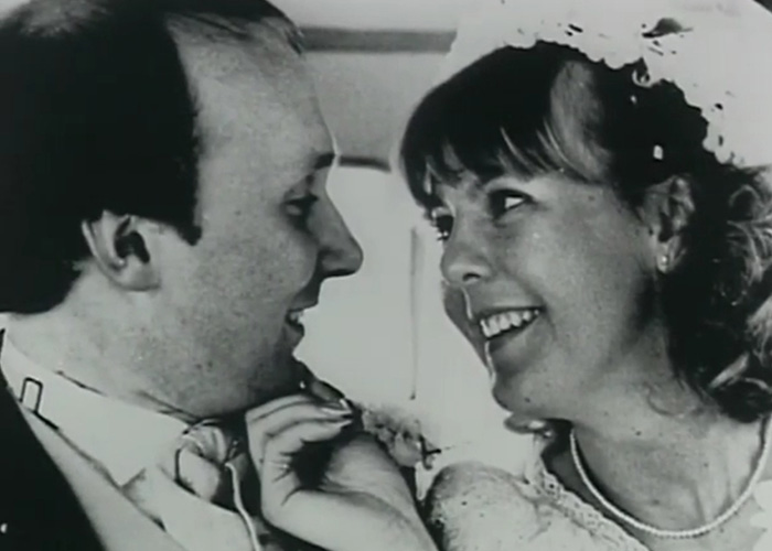 A black and white photo of a smiling couple, a man and a woman.