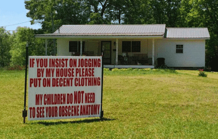 A sign in front of a house asking joggers to wear decent clothing, capturing a wildly different aspect of the USA.