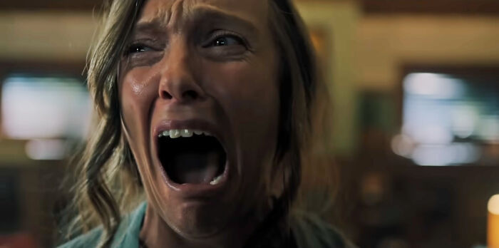 A woman with wide eyes and a mouth agape in a scream, depicting intense fear from the most terrifying horror movies.