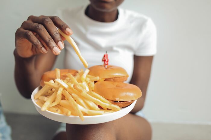 A person realizing they are the problem while eating fries and burgers.