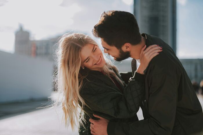 A happy couple embracing outdoors, reflecting on moments when they realized that they are the problem.