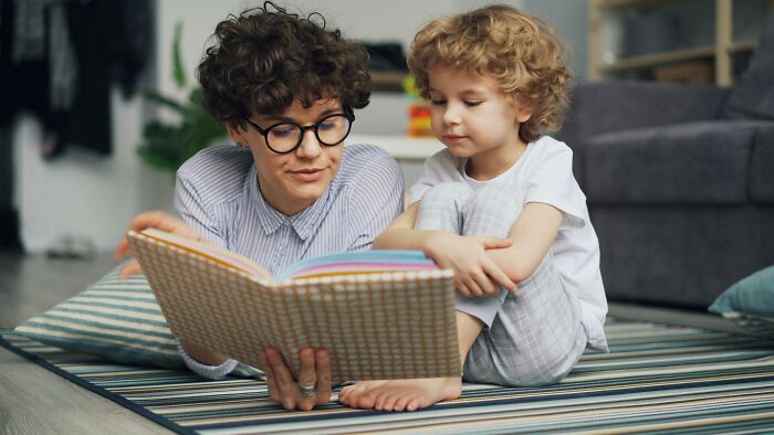 A parent and child read a book, illustrating a time parents were terrified of their own children.