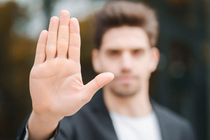 Man making a stop gesture, avoiding the worst things at a chaotic wedding.