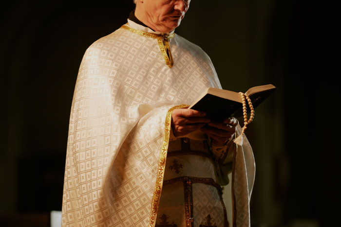 Priest reading from a holy book at a wedding, representing chaotic wedding moments.