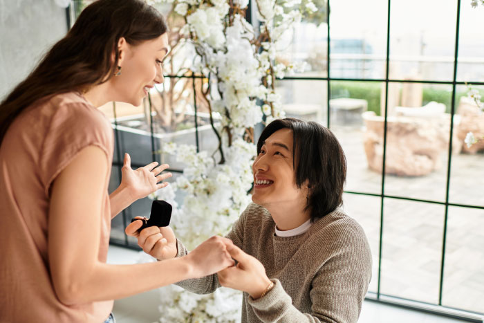 A joyful man proposes to a surprised woman, showing a worst thing at a wedding.