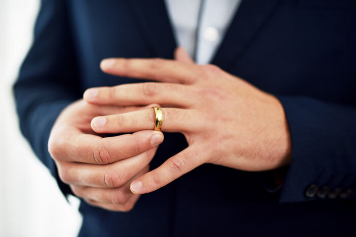 A man putting on a wedding ring, symbolizing commitment and the potential for life's instant justice moments.