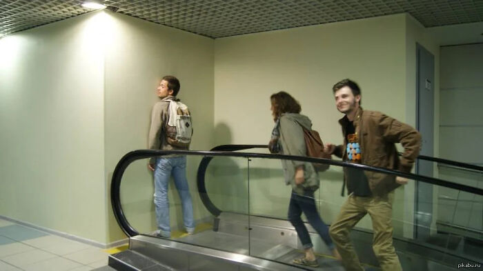 People on an escalator that leads directly into a wall, a major construction fail.