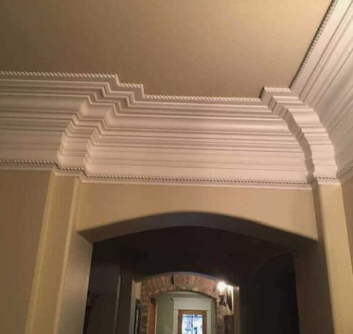 Intricate crown molding that abruptly changes style and ends awkwardly at a doorway, a clear construction fail.