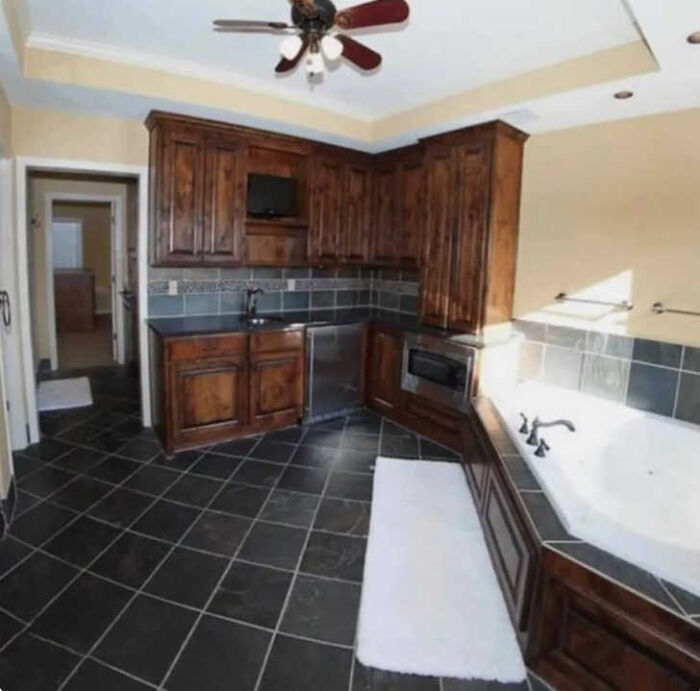 A bathroom with a kitchen-like setup, including a microwave and a mini-fridge, highlighting construction fails.