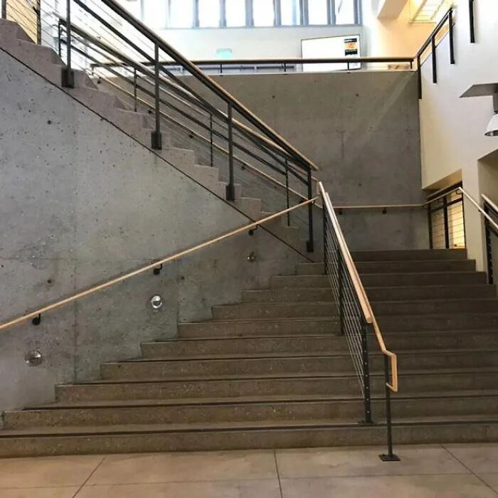 A construction fail: concrete stairs with handrails that don't align, appearing to lead nowhere.