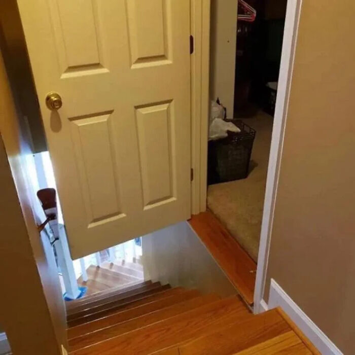 A door opens directly over a staircase, a dangerous construction fail where steps are missing.
