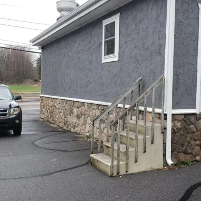 An outdoor concrete staircase ending abruptly without reaching the ground, highlighting construction fails.