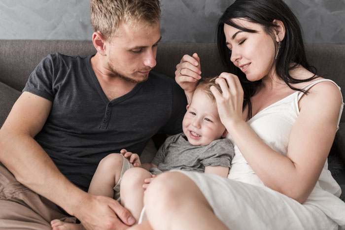 Man horrified by wife still expecting him to slog at home, sitting with his wife and child.