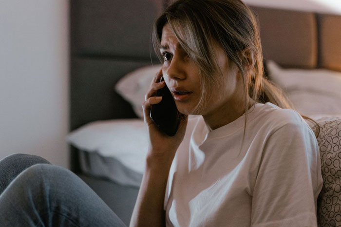 A worried woman on the phone, feeling distressed as a mother-in-law plans to make DIL have kids.