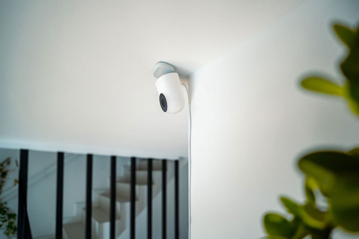 A white security camera mounted on a wall, crucial in a story where a mother-in-law wants grandbabies.