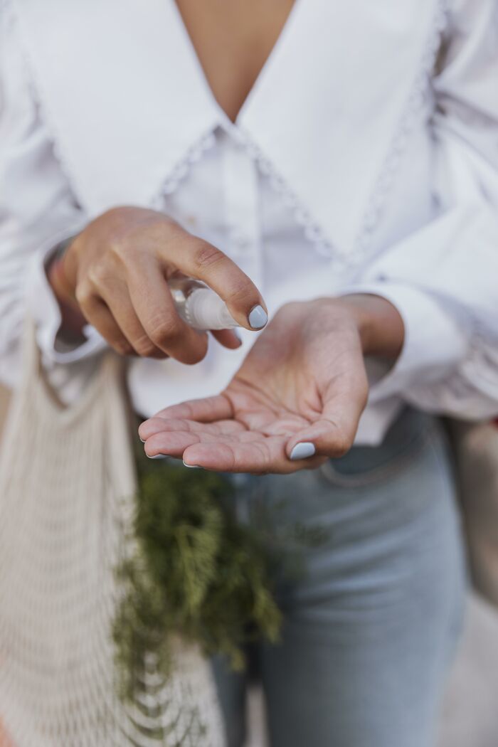 A person applying hand sanitizer, potentially regretting time and money spent at a wedding.