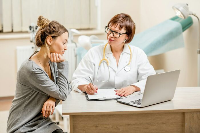 A gynecologist offering advice to a patient in a consultation room, emphasizing women's health.