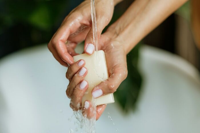 Hands washing with soap under running water, symbolizing hygiene advice from gynecologists for women.