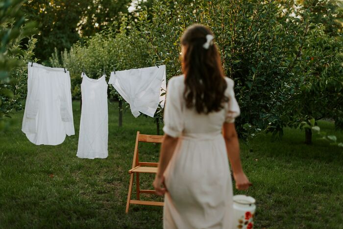 A woman hanging white laundry on a clothesline, reflecting advice from gynecologists on personal care.
