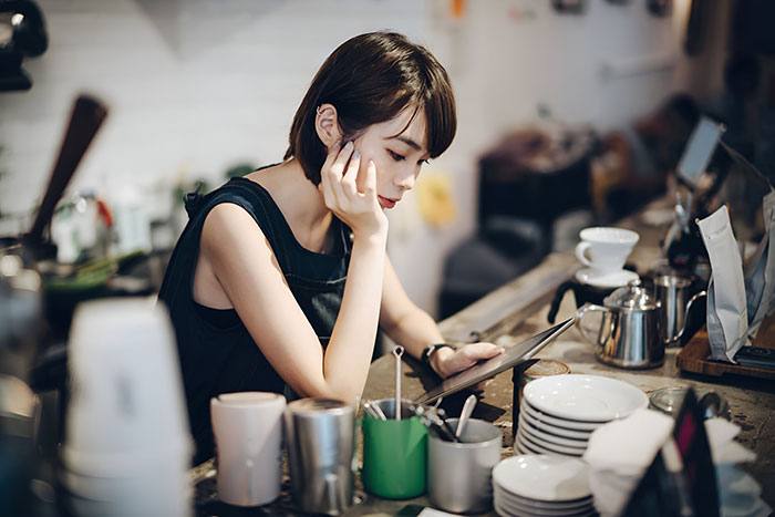 A 17YO slacking off at work, looking at a tablet, amidst made-up bullying claims involving a 19YO colleague. A 17YO slacking off at work, looking at a tablet, amidst made-up bullying claims involving a 19YO colleague.