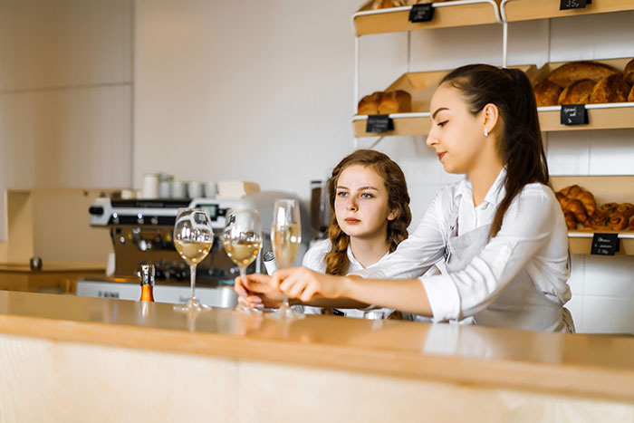 A 17-year-old colleague slacks off at work every day while a 19-year-old colleague looks on. A 17-year-old colleague slacks off at work every day while a 19-year-old colleague looks on.