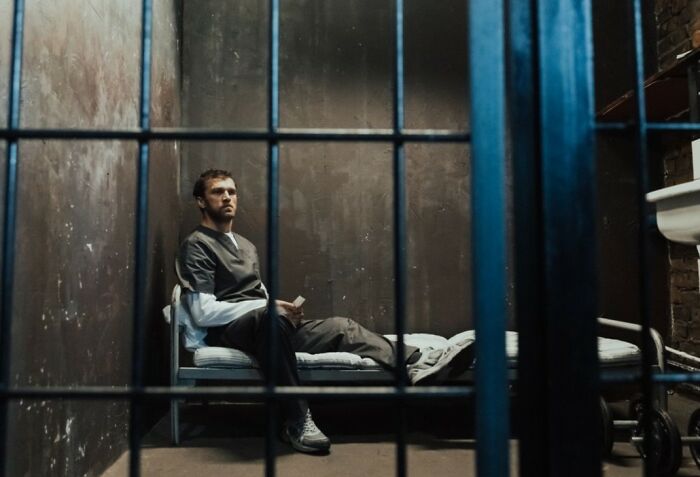 A man in a prison cell, contemplating first date red flags.