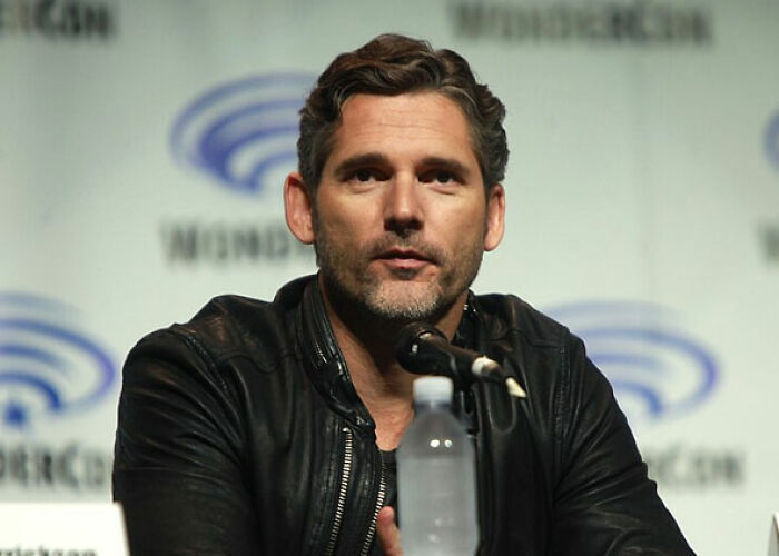 Headshot of a serious celebrity Eric Bana in a black leather jacket, speaking into a microphone. This captures one of the worst moments people asked celebrities for a photo.