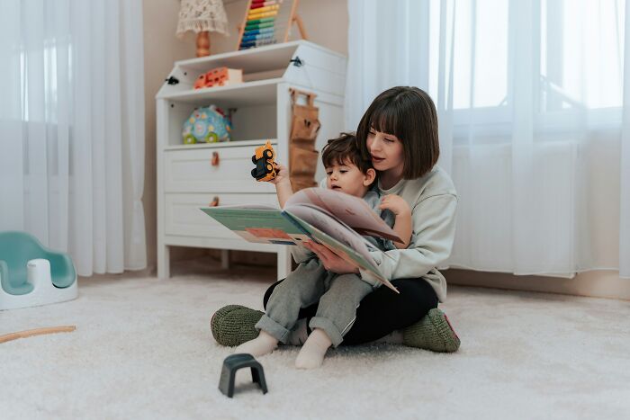 A mother and her child reading a book, representing infuriating MILs stories.