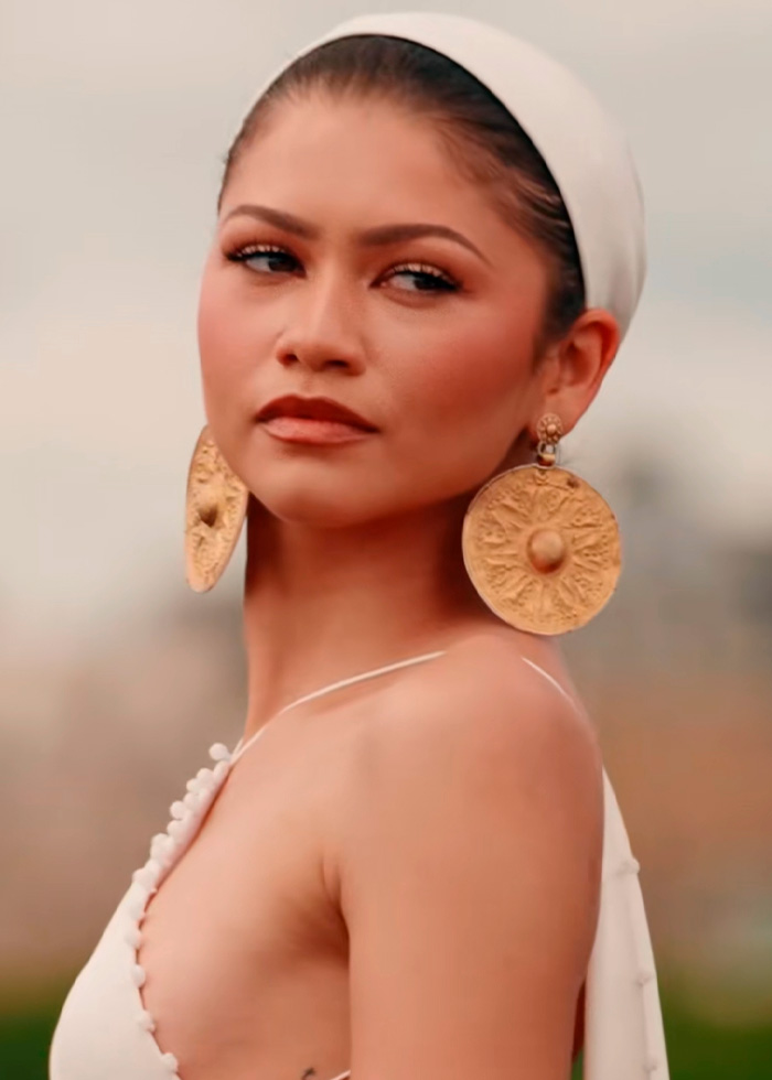 Zendaya wearing 3000-year-old earrings and white headwrap, sparking controversy. Zendaya wearing 3000-year-old earrings and white headwrap, sparking controversy.