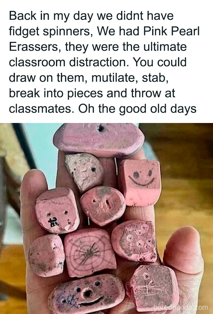 A hand holding old, worn Pink Pearl Erasers, a nostalgic '90s kid classroom distraction.