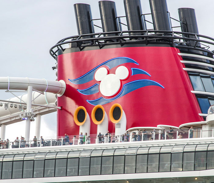 A Disney Cruise ship funnels with a Mickey Mouse logo, central to the cruise passenger story.