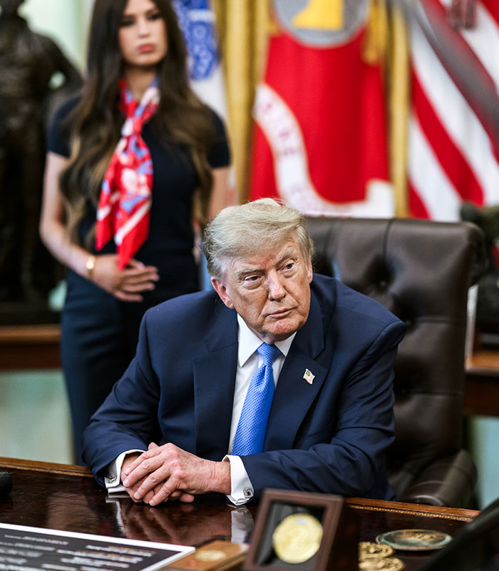 A mystery woman behind Trump at a desk. Her strange gesture sparked a wild theory. A mystery woman behind Trump at a desk. Her strange gesture sparked a wild theory.