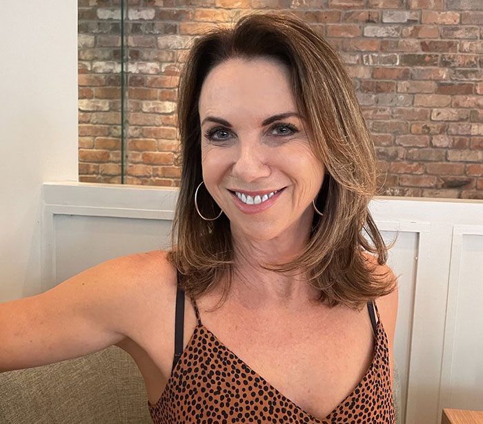 A relationship expert smiling, discussing cheating actions people don't realize are cheating.