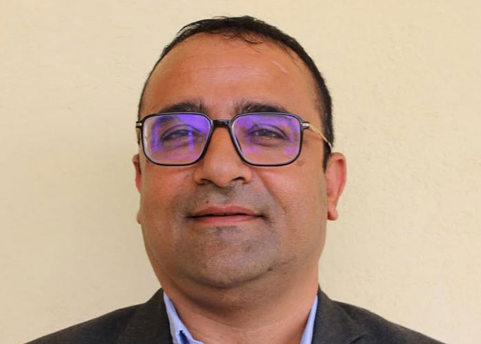 Close-up of the hero teacher who saved children from Nepal floods, wearing glasses and a blue shirt. Close-up of the hero teacher who saved children from Nepal floods, wearing glasses and a blue shirt.