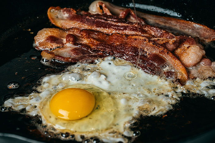 A common breakfast habit with bacon and fried egg in a pan, linked to higher mortality risk, especially after age 40. A common breakfast habit with bacon and fried egg in a pan, linked to higher mortality risk, especially after age 40.