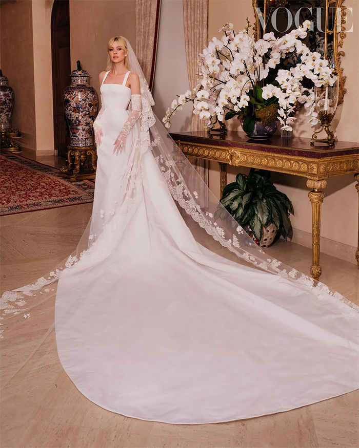 A bride in a white wedding gown with a long train and veil stands elegantly, capturing the essence of the wedding. A bride in a white wedding gown with a long train and veil stands elegantly, capturing the essence of the wedding.