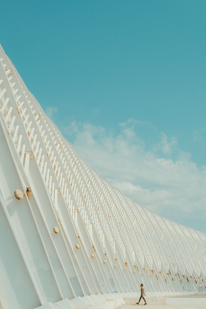 Architectural minimalist photography of a modern white building with repeating patterns against a blue sky.