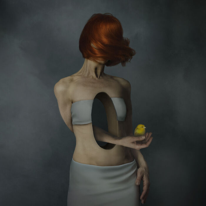 Extraordinary minimalist photography of a woman with a hollow torso holding a small yellow bird.