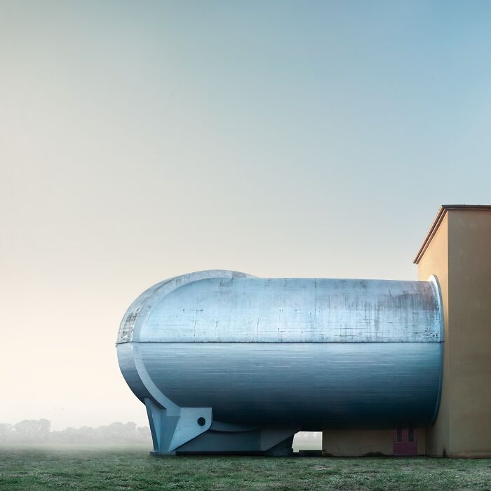 A minimalist photography awards image of two large spherical buildings connected by a walkway, set against a cloudy sky.