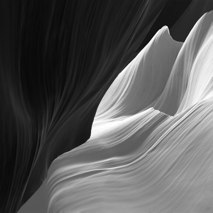 A black and white image capturing the stunning curves of Antelope Canyon, a highlight from the Minimalist Photography Awards.