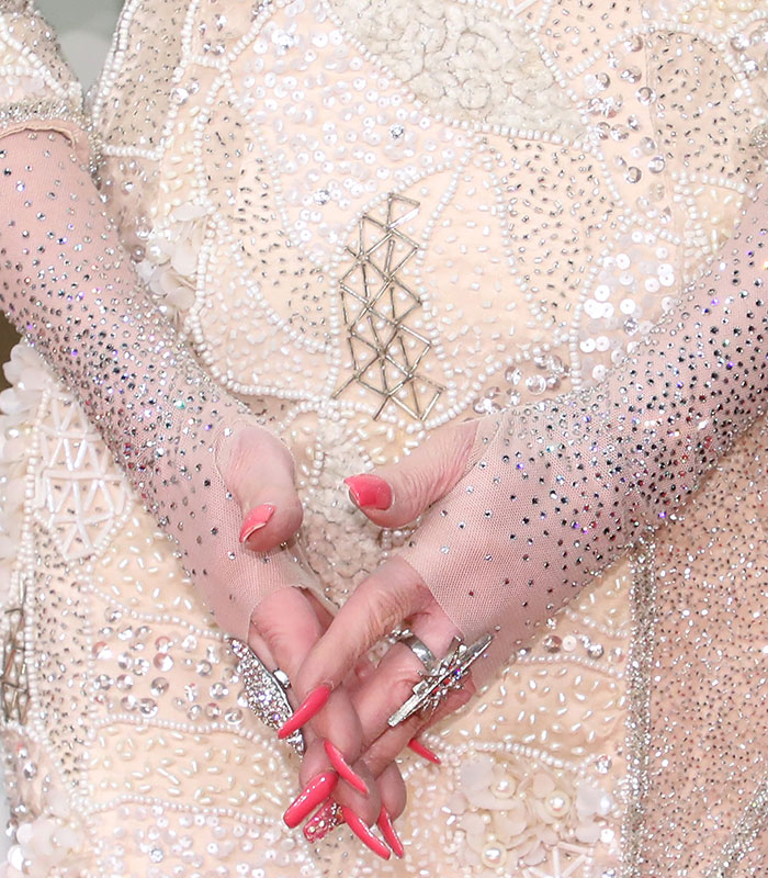 Close-up of Dolly Parton's elegant skin-colored gloves covering her tattooed hands. Close-up of Dolly Parton's elegant skin-colored gloves covering her tattooed hands.