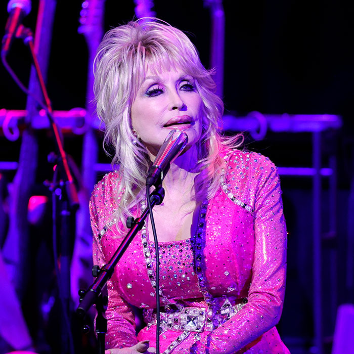 Dolly Parton in a sparkly pink outfit at a microphone, symbolizing the fight against cancer and the importance of symptom awareness. Dolly Parton in a sparkly pink outfit at a microphone, symbolizing the fight against cancer and the importance of symptom awareness.