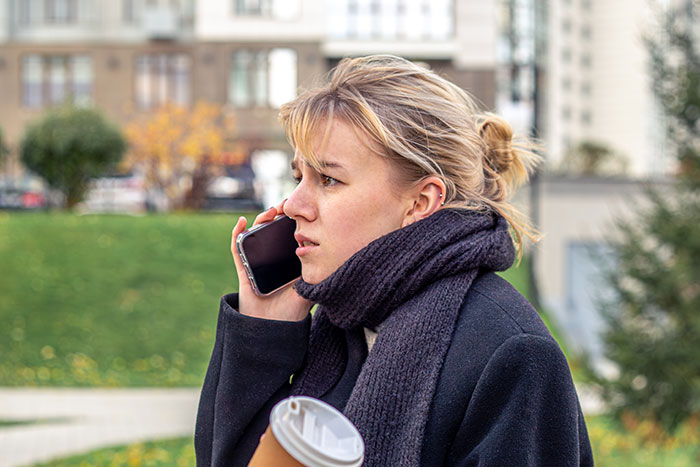 A woman on the phone, looking concerned. This image relates to a wife's jealousy and a secret police call.