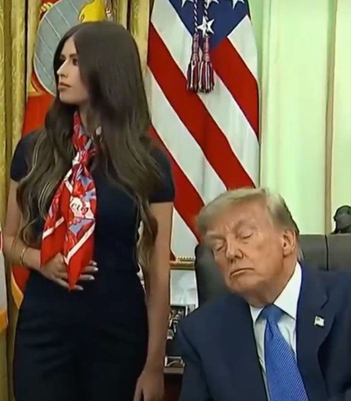 A mystery woman with a strange gesture stands behind a sleeping Donald Trump, sparking a wild theory. A mystery woman with a strange gesture stands behind a sleeping Donald Trump, sparking a wild theory.