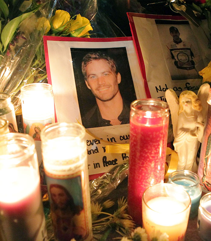 Paul Walker controversy tribute: A memorial with candles and a photo of Paul Walker, reflecting ongoing public sentiment.