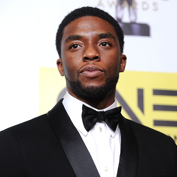 Chadwick Boseman in a suit, reflecting on a doctor's insights into cancer symptoms most people dismiss. Chadwick Boseman in a suit, reflecting on a doctor's insights into cancer symptoms most people dismiss.