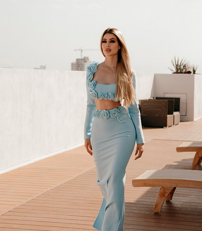 A beauty influencer in a light blue two-piece outfit outdoors, connected to a cartel boss assassination. A beauty influencer in a light blue two-piece outfit outdoors, connected to a cartel boss assassination.