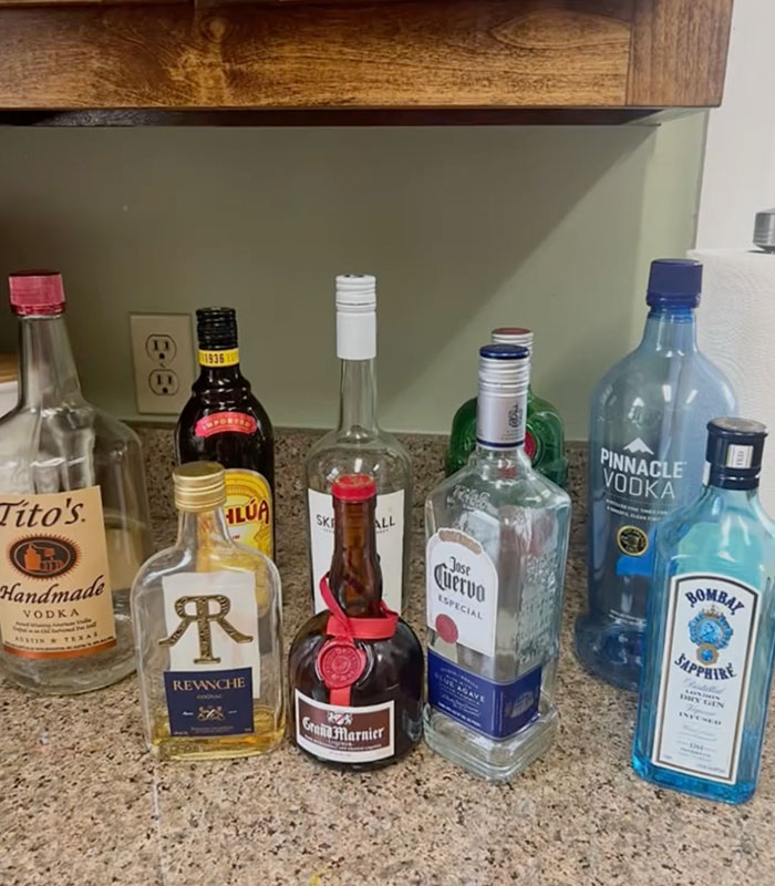 Various empty alcohol bottles on a counter, possibly related to a husband's cheating discovered by a private investigator. Various empty alcohol bottles on a counter, possibly related to a husband's cheating discovered by a private investigator.