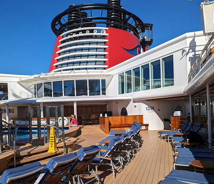 The deck of a Disney Cruise ship with lounge chairs, relevant to the cruise passenger's experience.