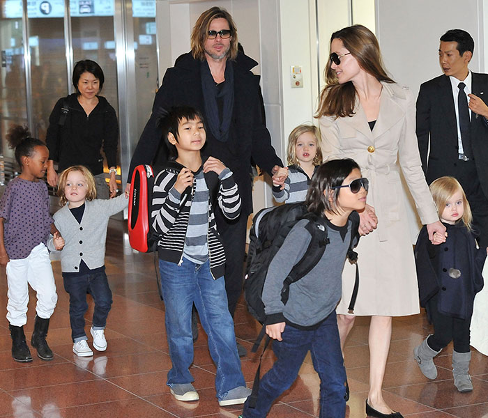 Brad Pitt and Angelina Jolie with their six children at an airport, showcasing their family life amidst sobriety news. Brad Pitt and Angelina Jolie with their six children at an airport, showcasing their family life amidst sobriety news.